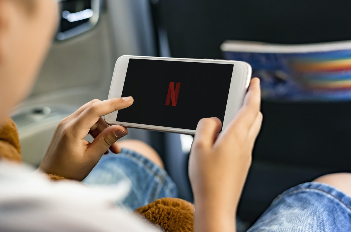 child in car watching netflix on phone