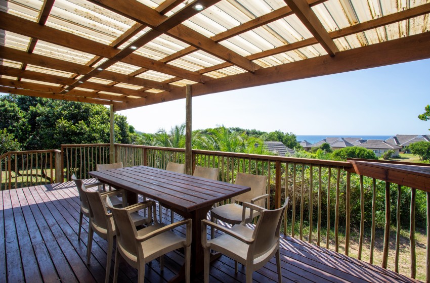 deck with dining table with sea view at Baleia Azul 16 in Ponta Mamoli