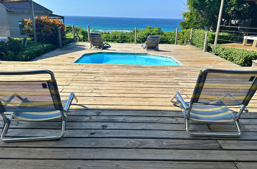 sun loungers and swimming pool at Baleia Azul 11 in Ponta Mamoli